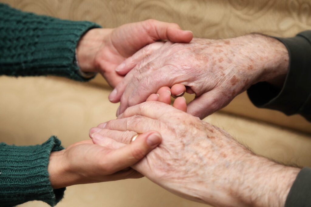 personne tenant les mains d'une personne agée