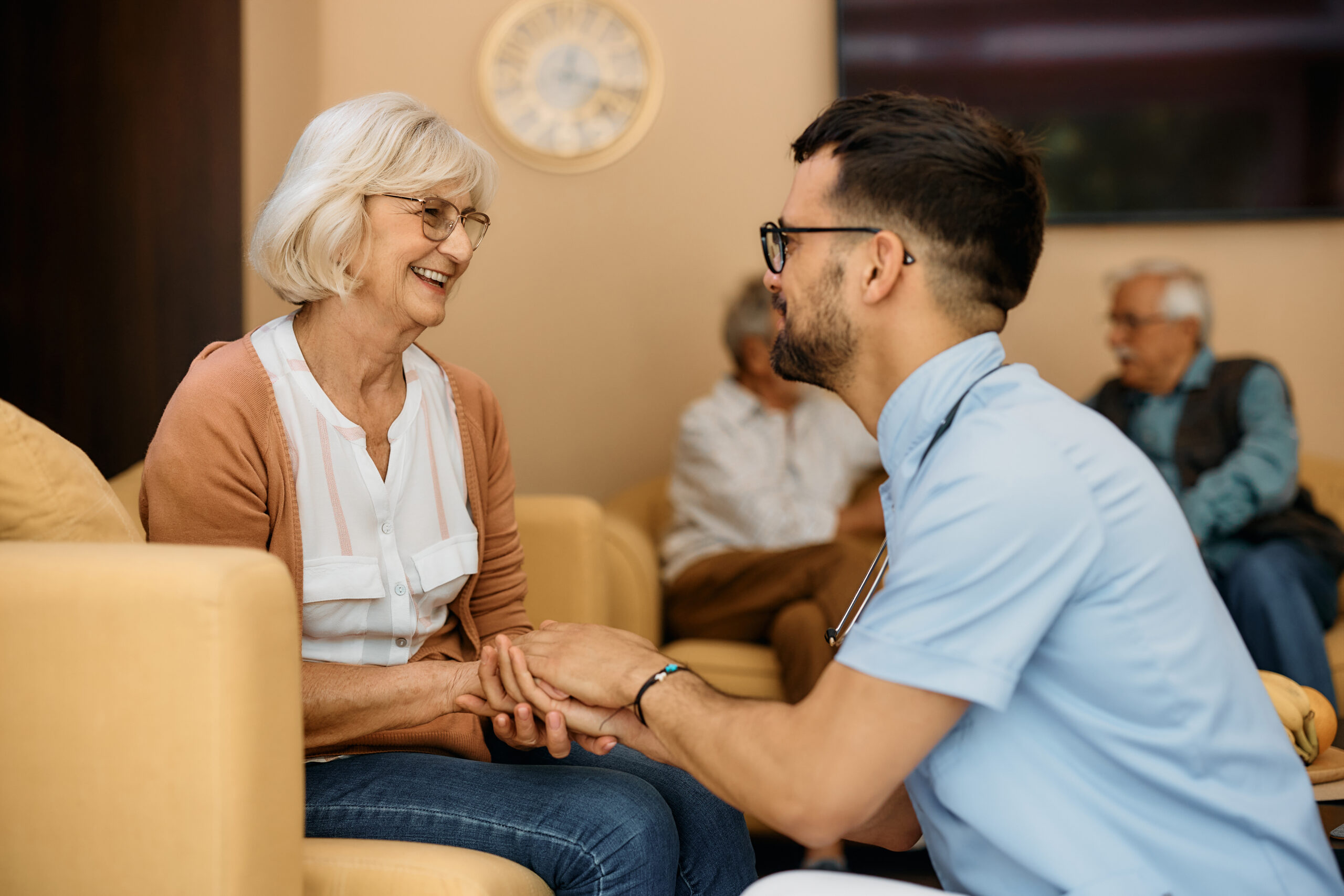 personne âgée discutant avec un soignant en souriant